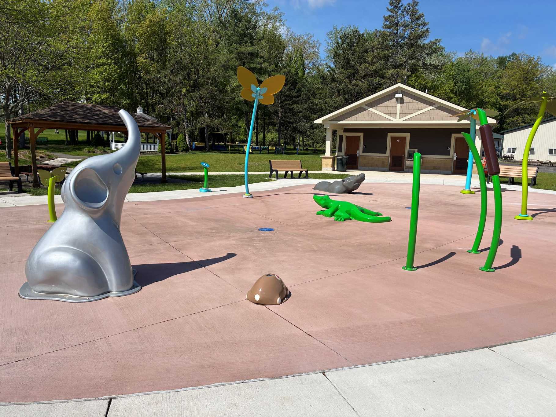A large playground featuring a giant elephant sculpture alongside various animal-themed play structures. - Copy